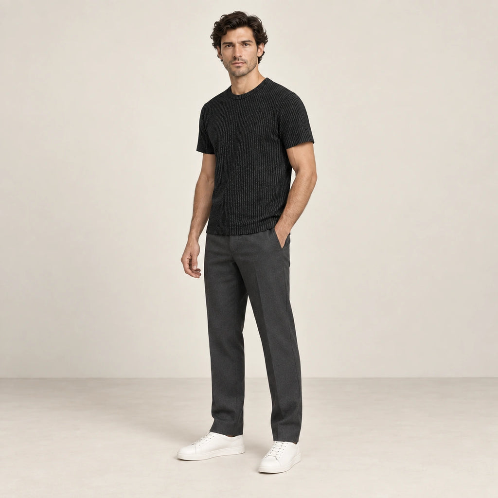 T-shirt noir en maille jacquard à fines lignes verticales, porté de trois-quarts dans le studio IVAREE.