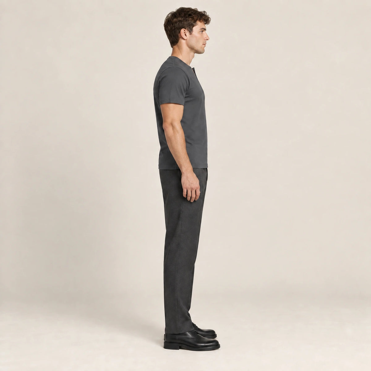 T-shirt slim en coton gris foncé à col fendu et manches courtes, vue de profil dans le studio IVAREE.