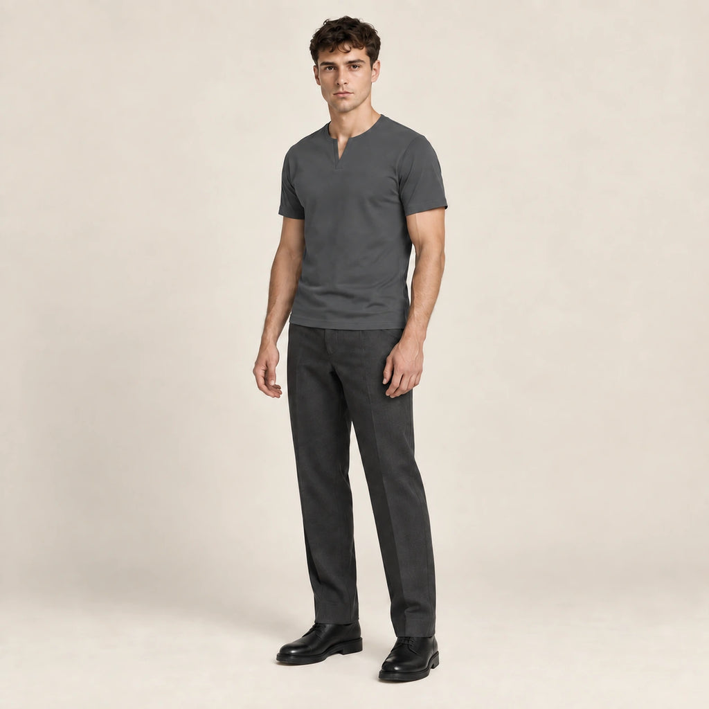 T-shirt slim en coton gris foncé à col fendu et manches courtes, porté de trois-quarts dans le studio IVAREE.