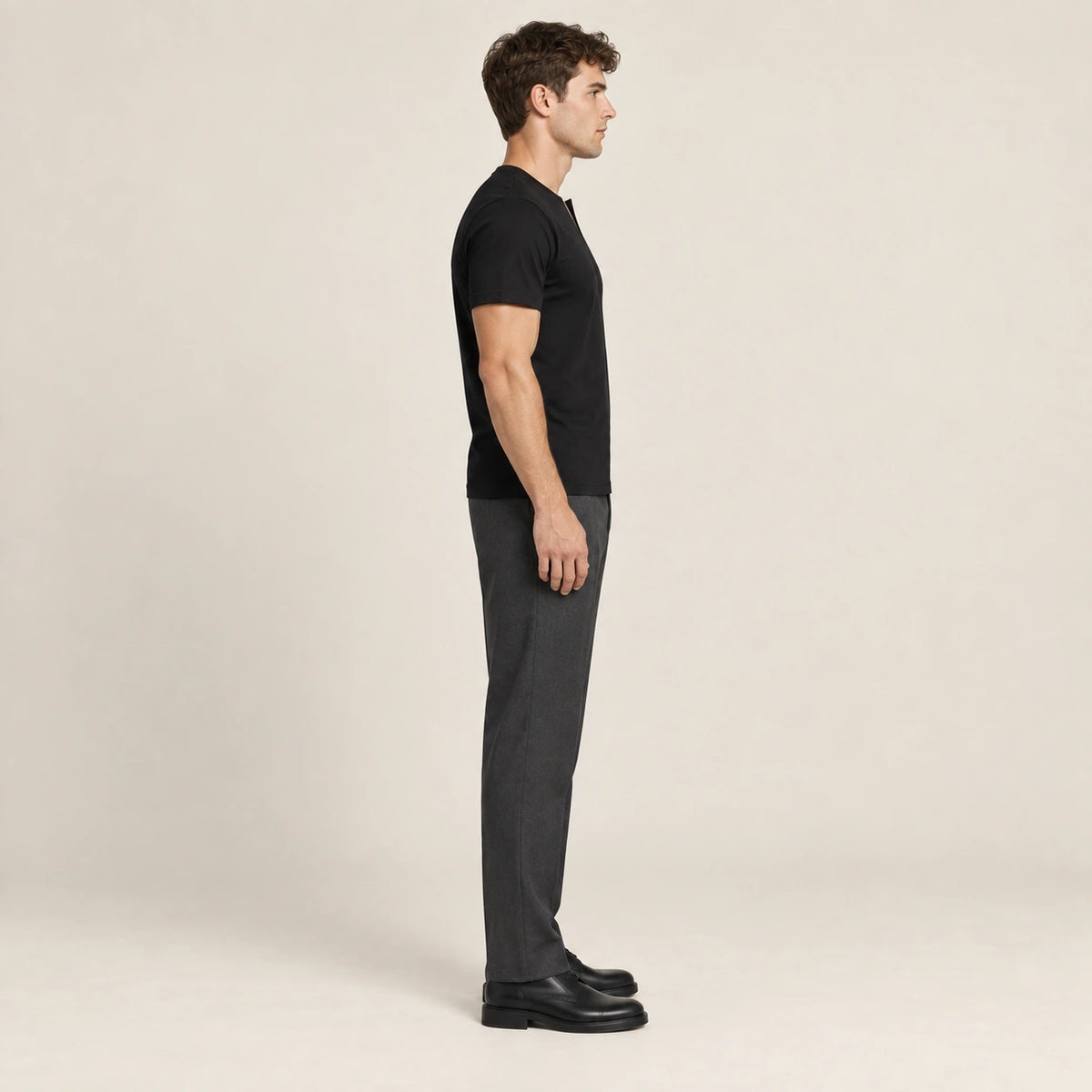 T-shirt slim en coton noir à col fendu et manches courtes, vue de profil dans le studio IVAREE.
