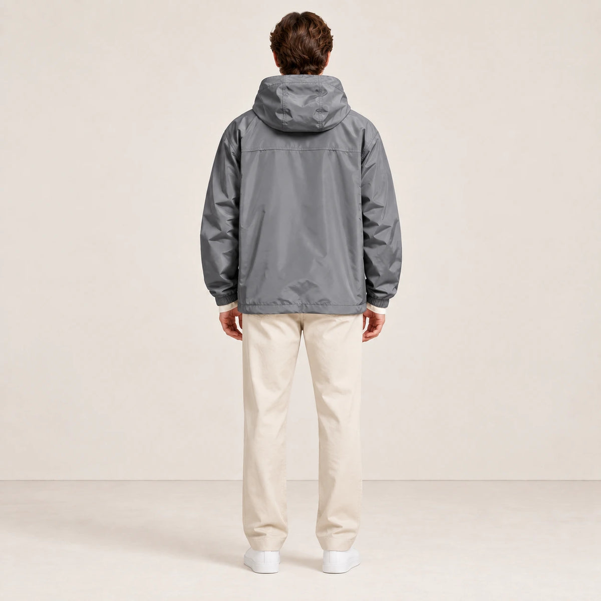 Veste à capuche grise portée de dos dans le studio IVAREE.