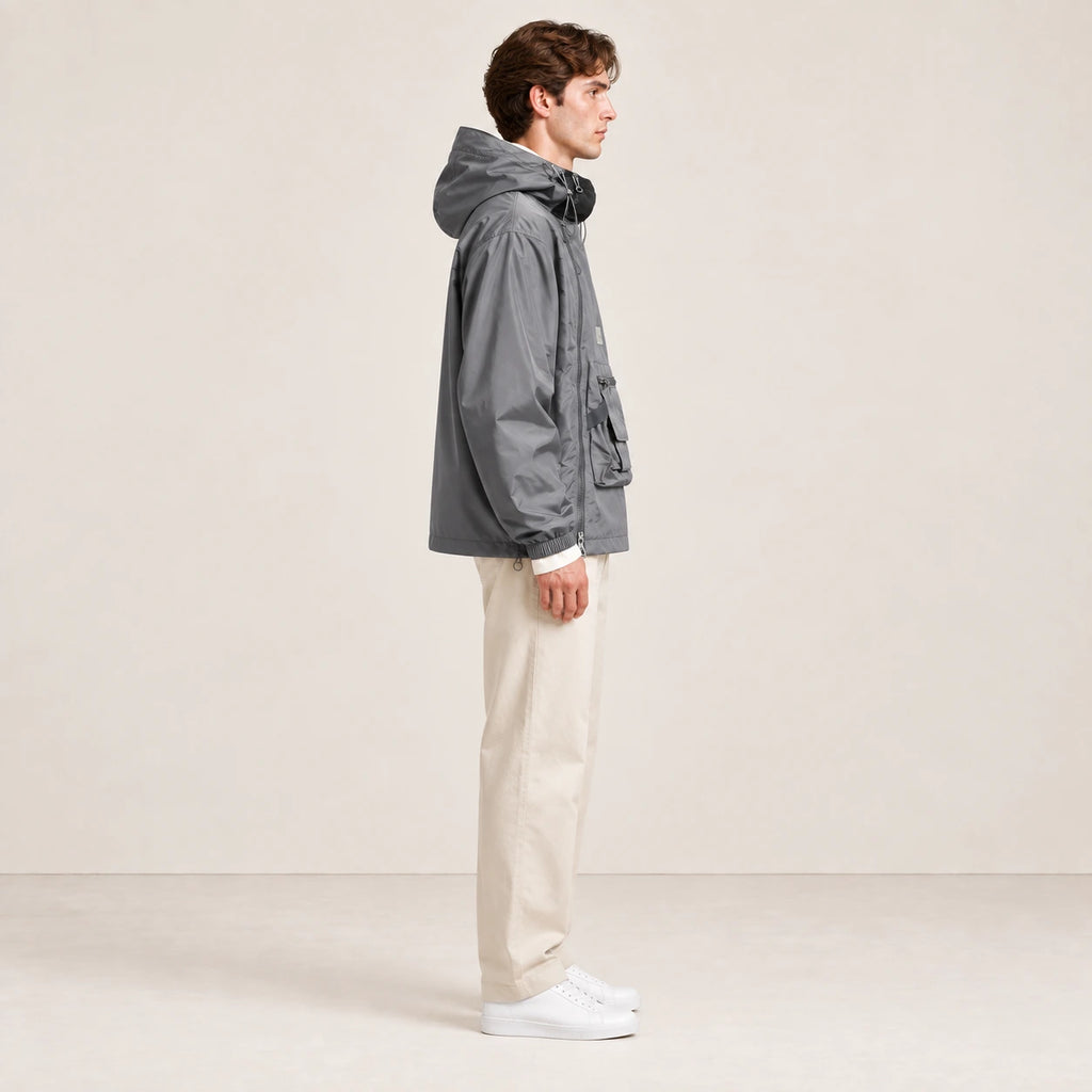 Veste à capuche grise portée de profil dans le studio IVAREE.