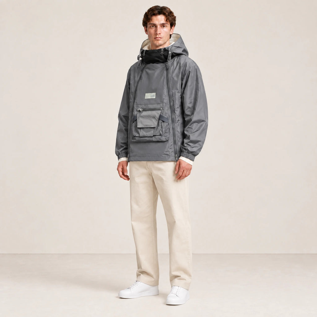 Veste à capuche grise portée de trois-quarts dans le studio IVAREE.