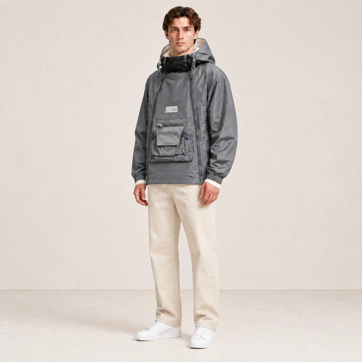 Veste à capuche grise portée de trois-quarts dans le studio IVAREE.