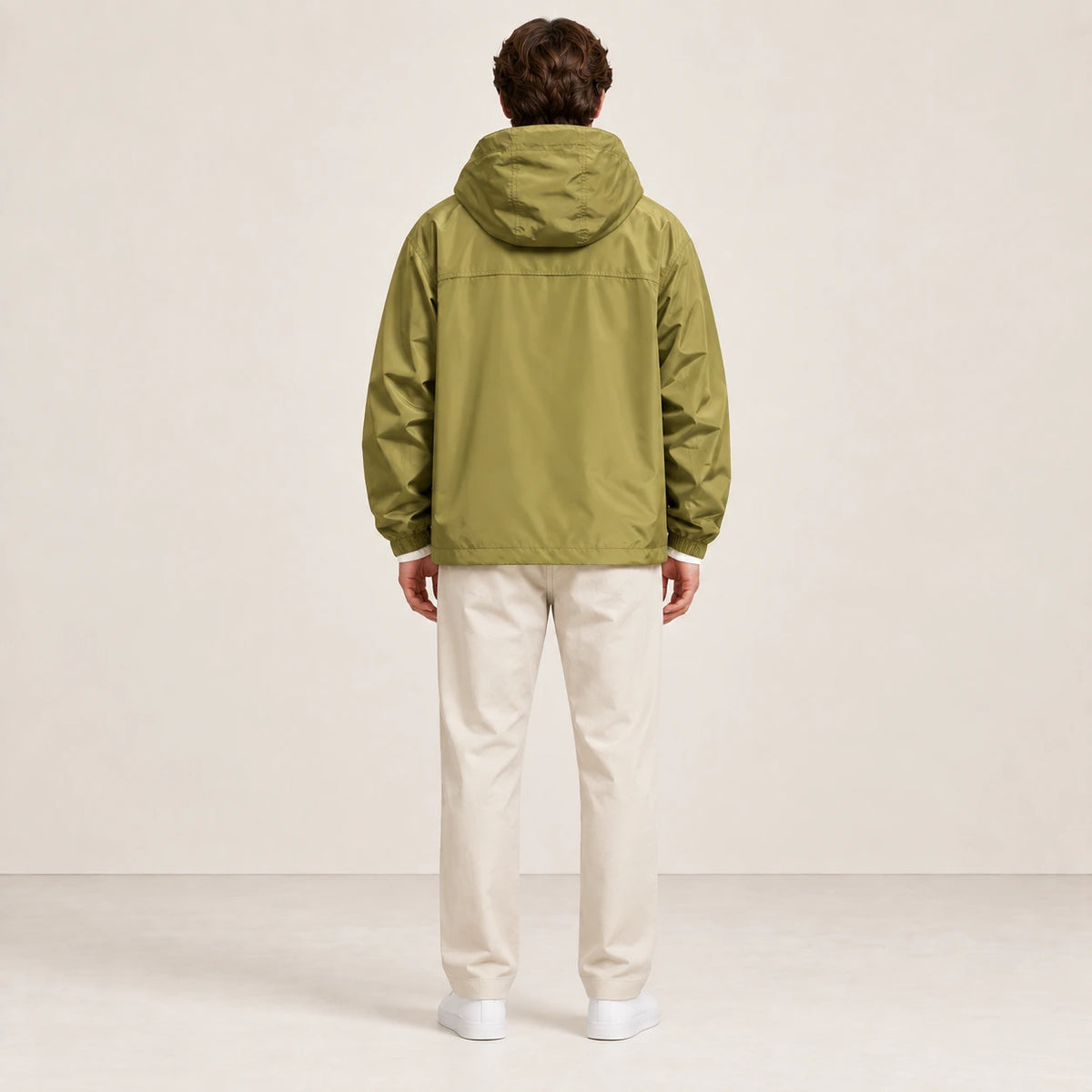 Veste à capuche kaki portée de dos dans le studio IVAREE.