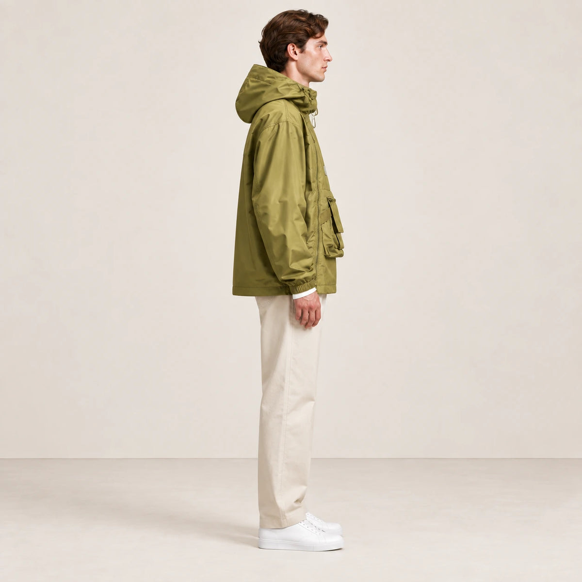 Veste à capuche kaki portée de profil dans le studio IVAREE.