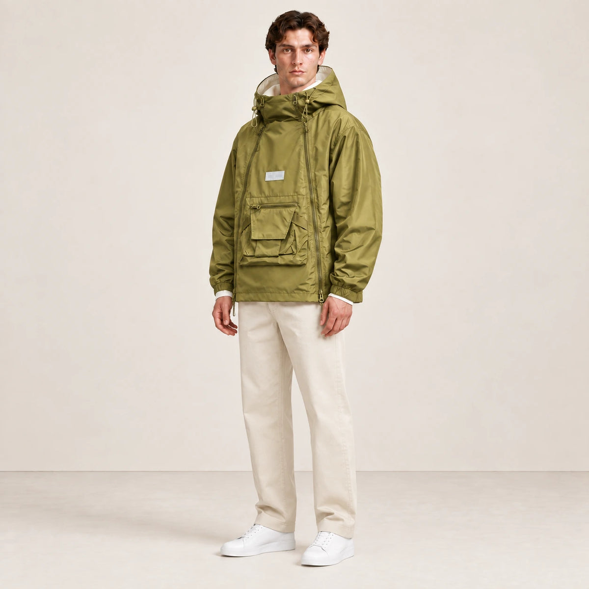 Veste à capuche kaki portée de trois-quarts dans le studio IVAREE.