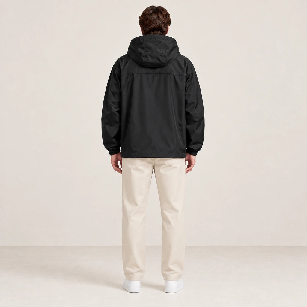 Veste à capuche noire portée de dos dans le studio IVAREE.