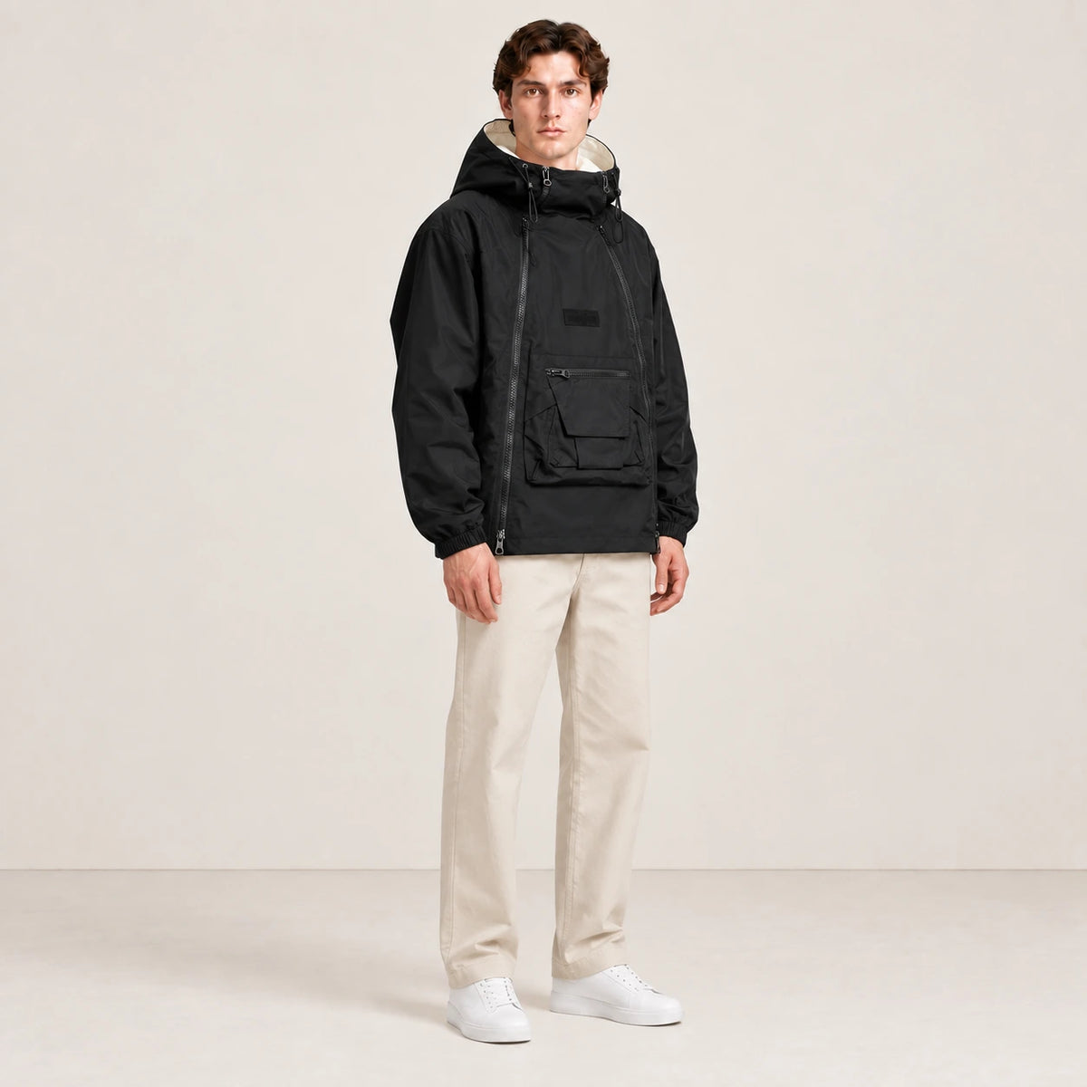 Veste à capuche noire portée de trois-quarts dans le studio IVAREE.