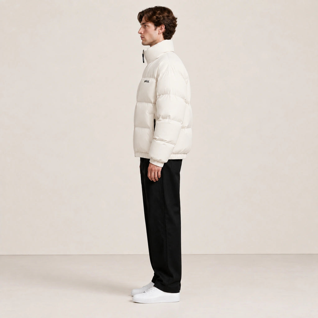 Veste d’hiver abricot à col montant, portée de profil dans le studio IVAREE.
