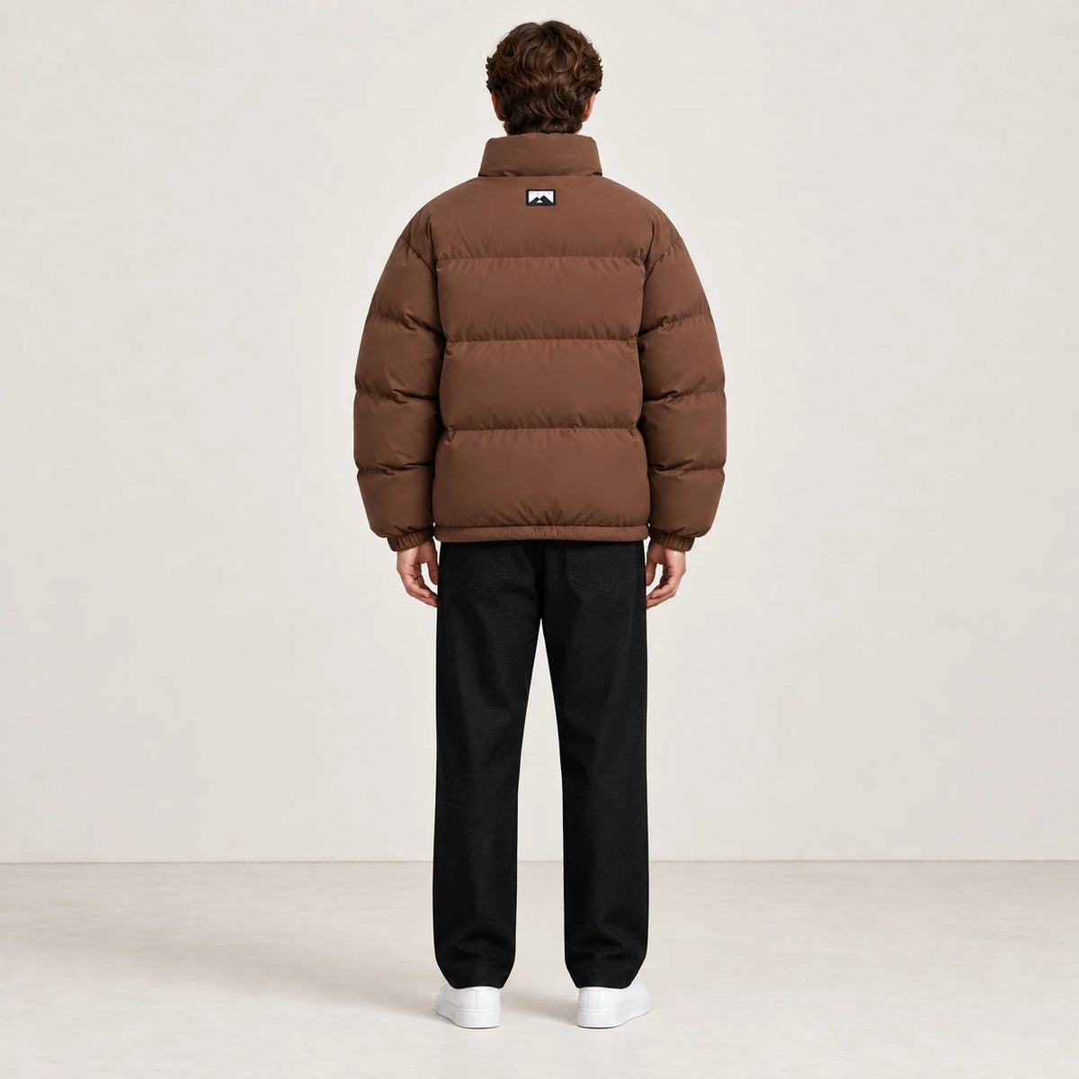 Veste d’hiver marron clair à col montant, portée de dos dans le studio IVAREE.