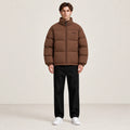 Veste d’hiver marron clair à col montant, portée de face dans le studio IVAREE.