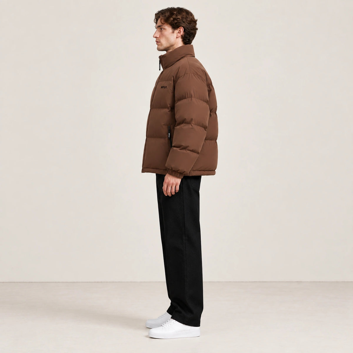 Veste d’hiver marron clair à col montant, portée de profil dans le studio IVAREE.