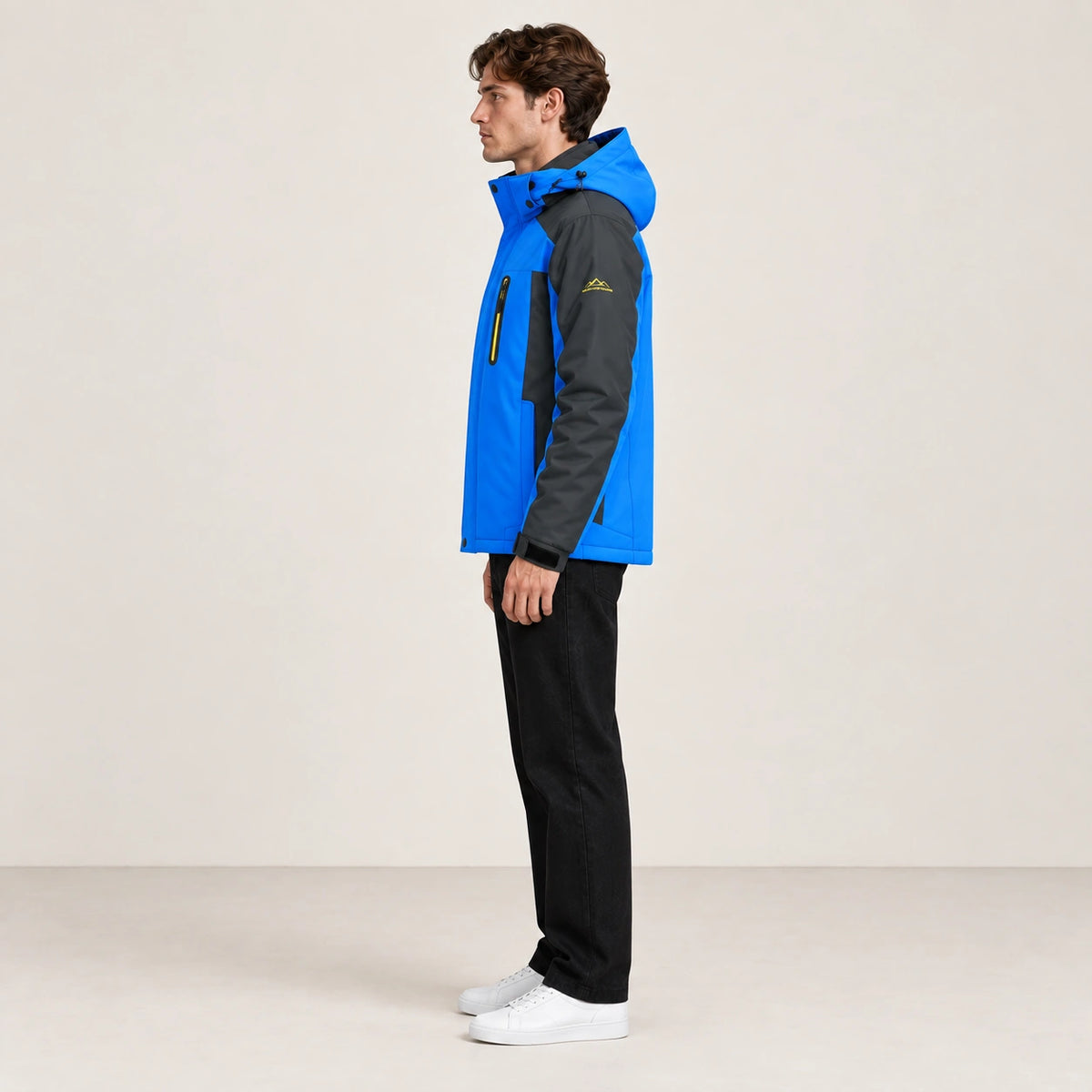 Veste d’hiver technique multipoche bleue, portée de profil dans le studio IVAREE.