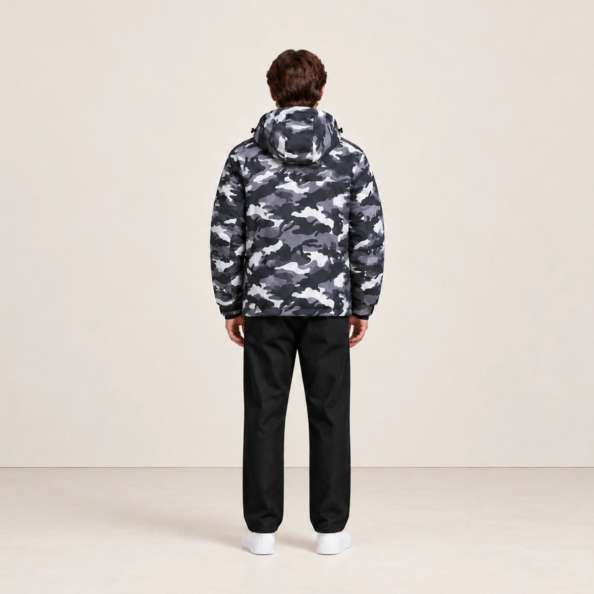 Veste d’hiver technique multipoche à motif camouflage, portée de dos dans le studio IVAREE.