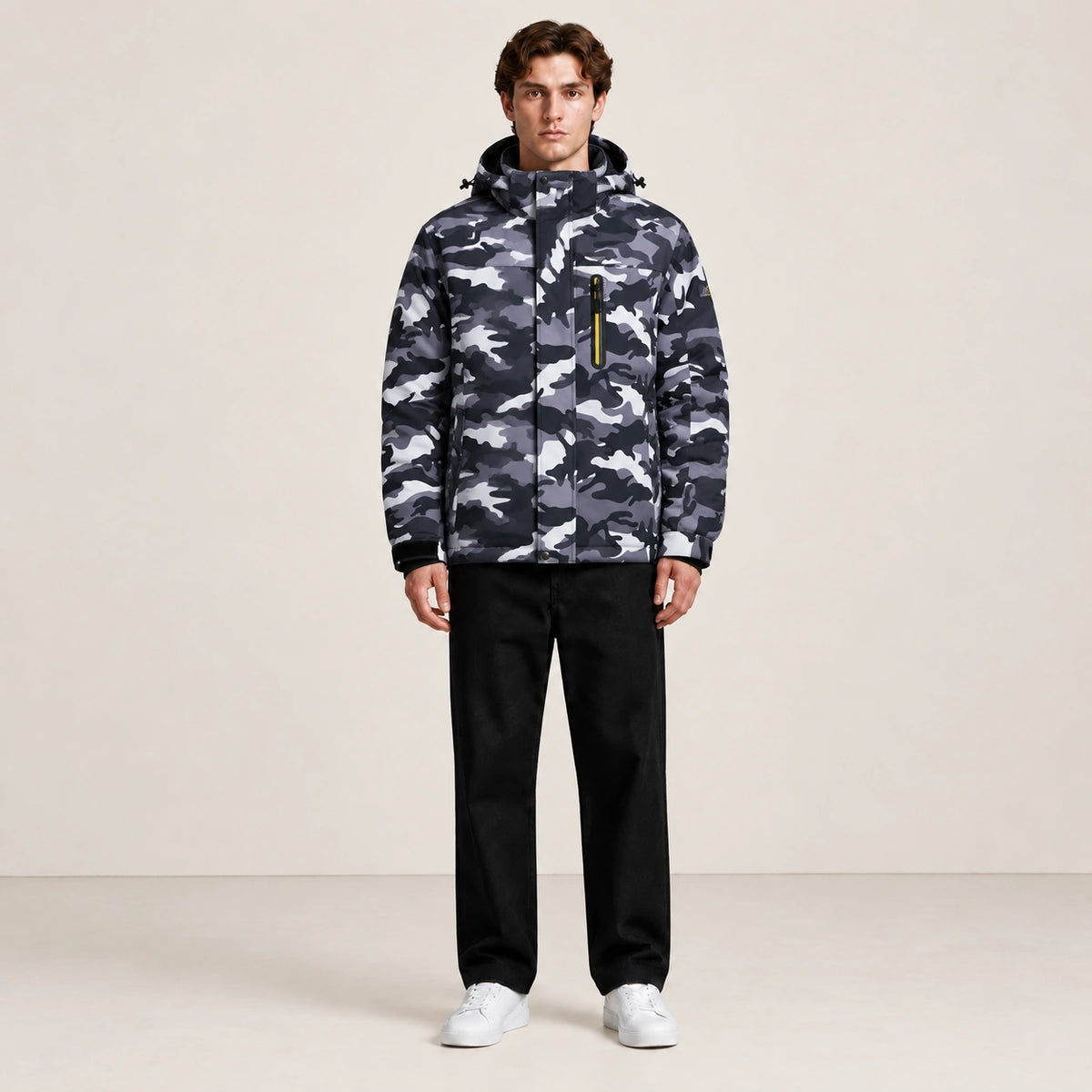 Veste d’hiver technique multipoche à motif camouflage, portée de face dans le studio IVAREE.