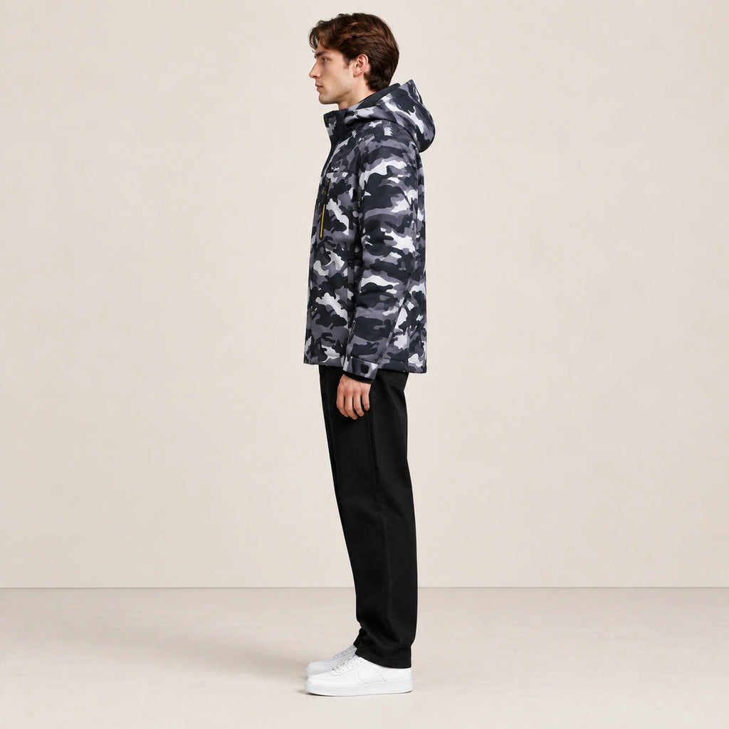 Veste d’hiver technique multipoche à motif camouflage, portée de profil dans le studio IVAREE.