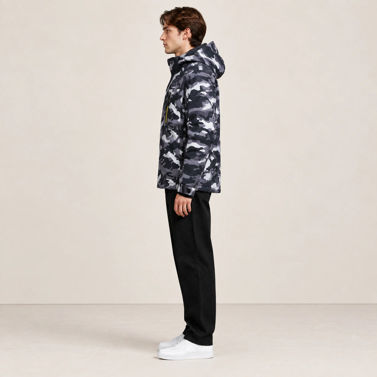 Veste d’hiver technique multipoche à motif camouflage, portée de profil dans le studio IVAREE.