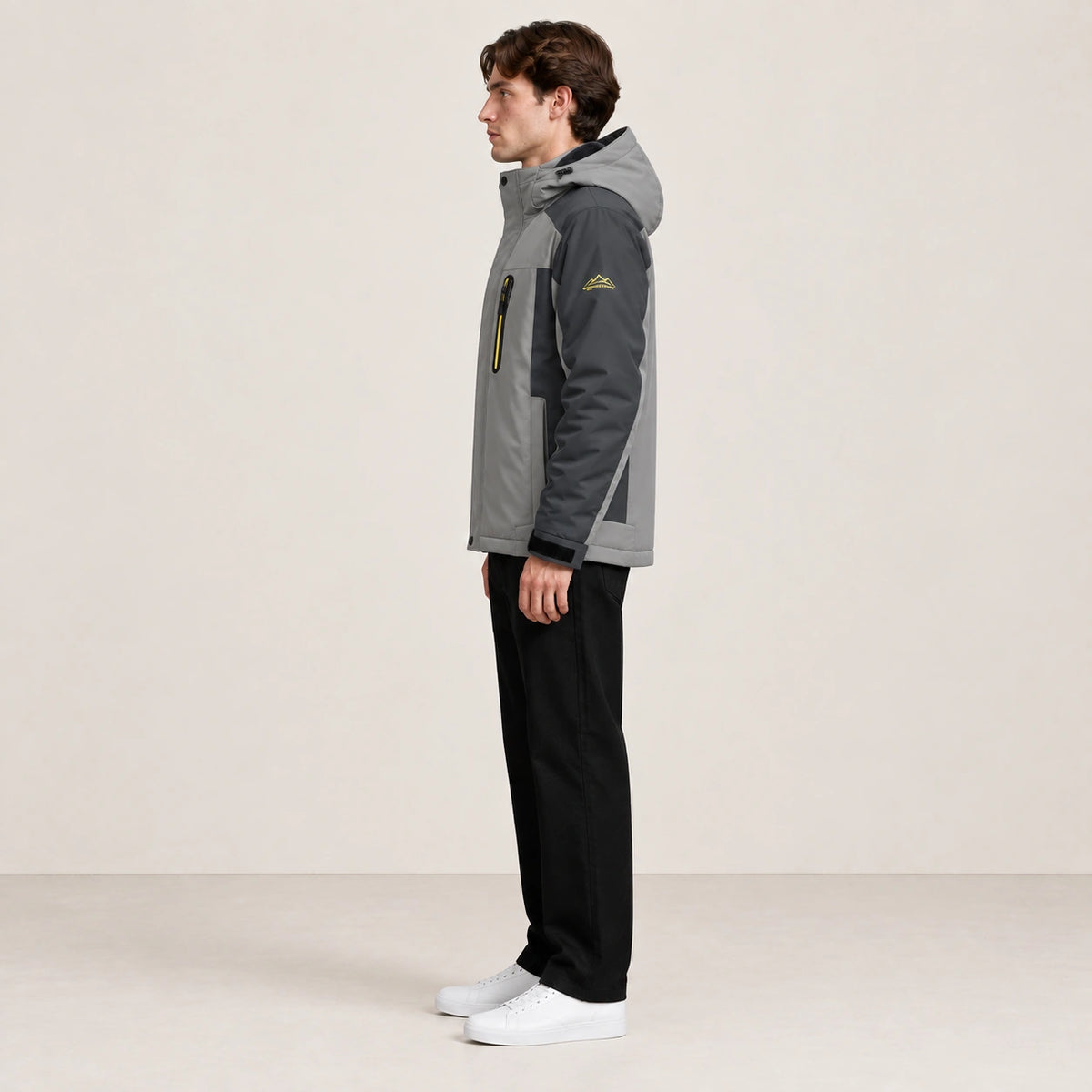 Veste d’hiver technique multipoche gris clair, portée de profil dans le studio IVAREE.