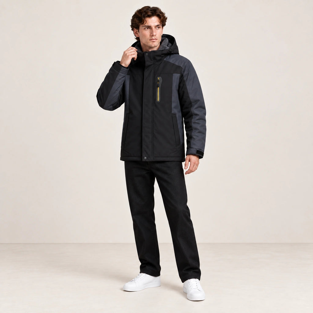 Veste d’hiver technique multipoche noire, portée dans une pose naturelle dans le studio IVAREE.
