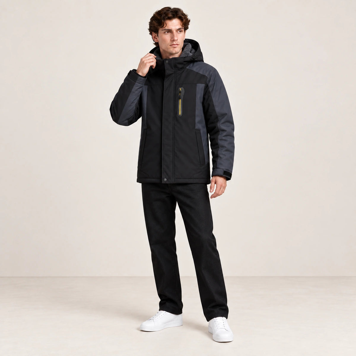Veste d’hiver technique multipoche noire, portée dans une pose naturelle dans le studio IVAREE.