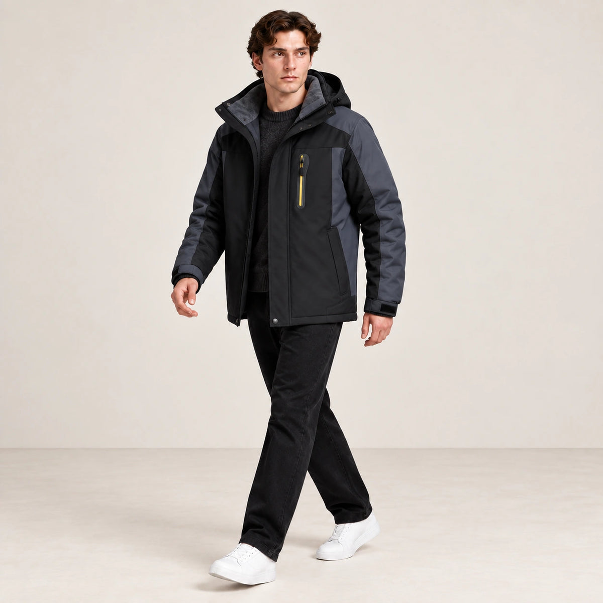 Veste d’hiver technique multipoche noire, portée de trois-quarts dans le studio IVAREE.