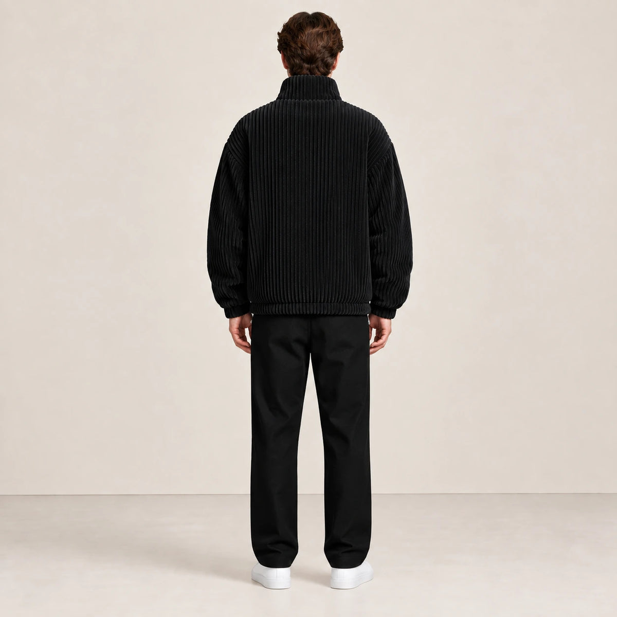 Veste d'hiver en velours côtelé noir, portée de dos dans le studio IVAREE.