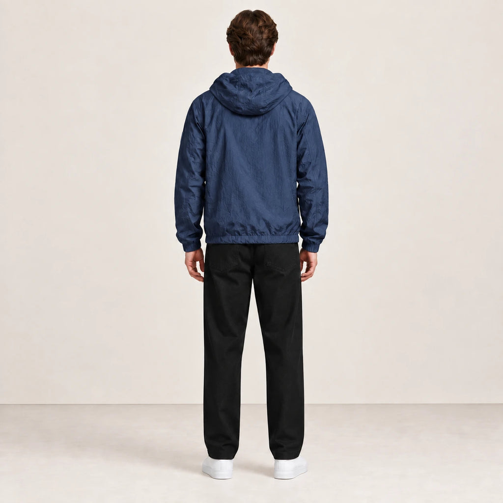 Veste légère bleu marine à capuche, portée de dos dans le studio IVAREE.