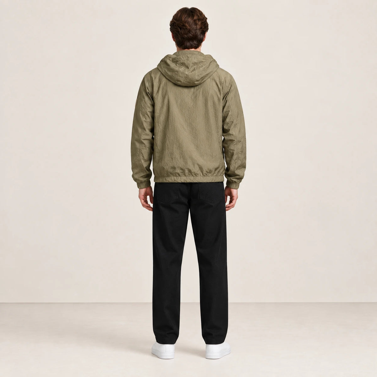 Veste légère kaki à capuche, portée de dos dans le studio IVAREE.
