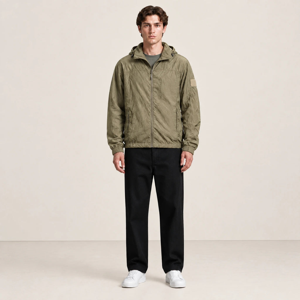 Veste légère kaki à capuche et fermeture zippée, portée de face dans le studio IVAREE.