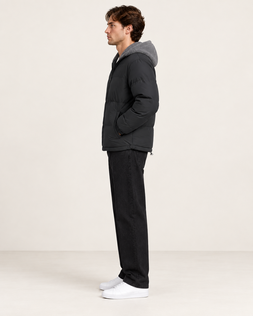 Veste matelassée à capuche gris, vue profil, dans le studio IVAREE.