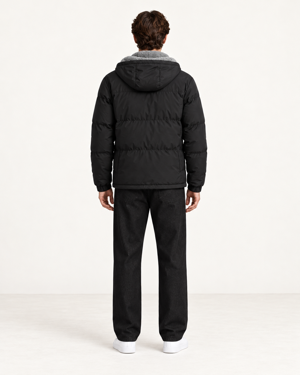Veste matelassée à capuche noir, vue dos, dans le studio IVAREE.