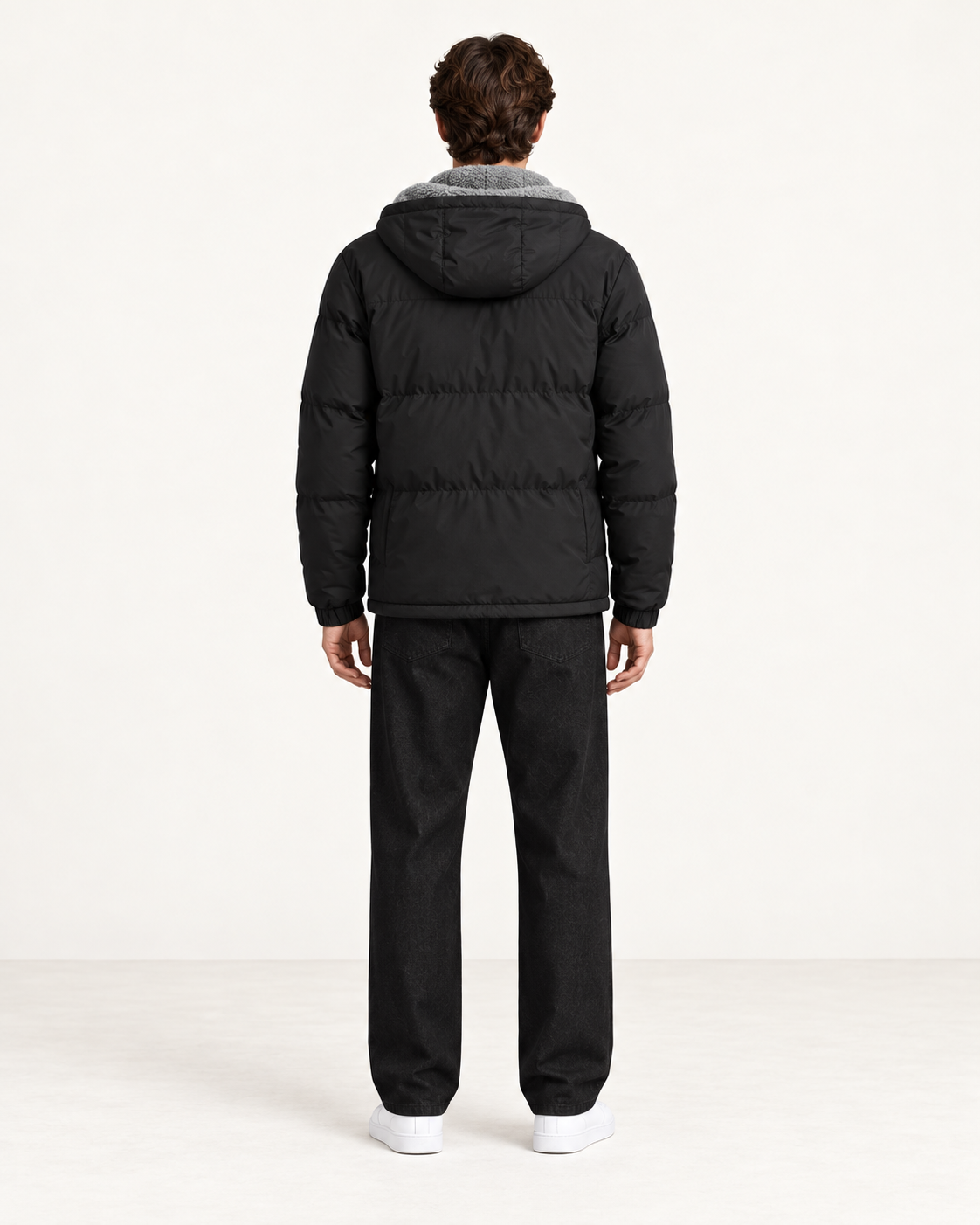 Veste matelassée à capuche noir, vue dos, dans le studio IVAREE.