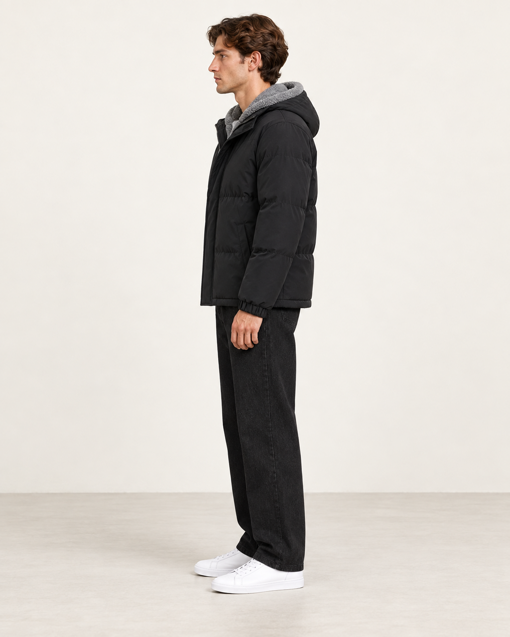 Veste matelassée à capuche noir, vue profil, dans le studio IVAREE.