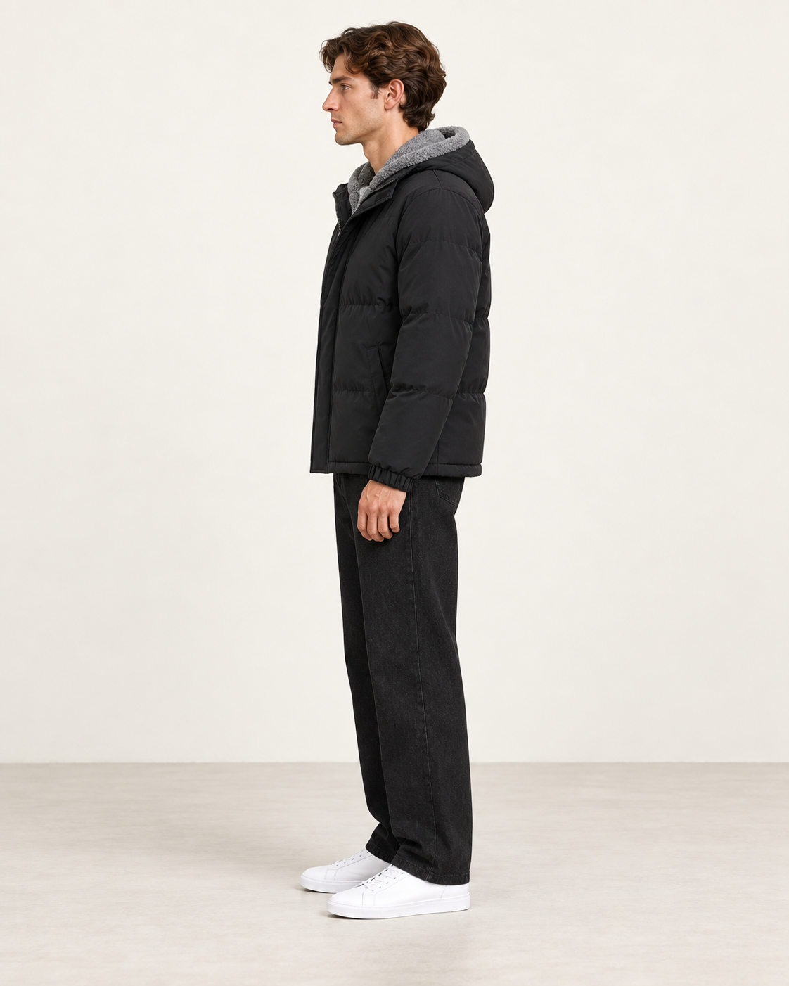 Veste matelassée à capuche noir, vue profil, dans le studio IVAREE.