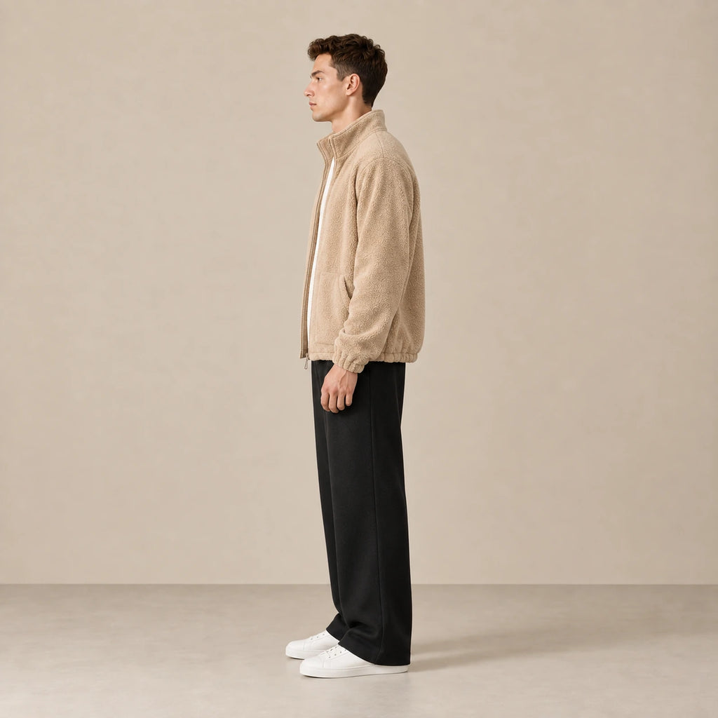 Veste polaire kaki clair à col montant, portée de profil dans le studio IVAREE.