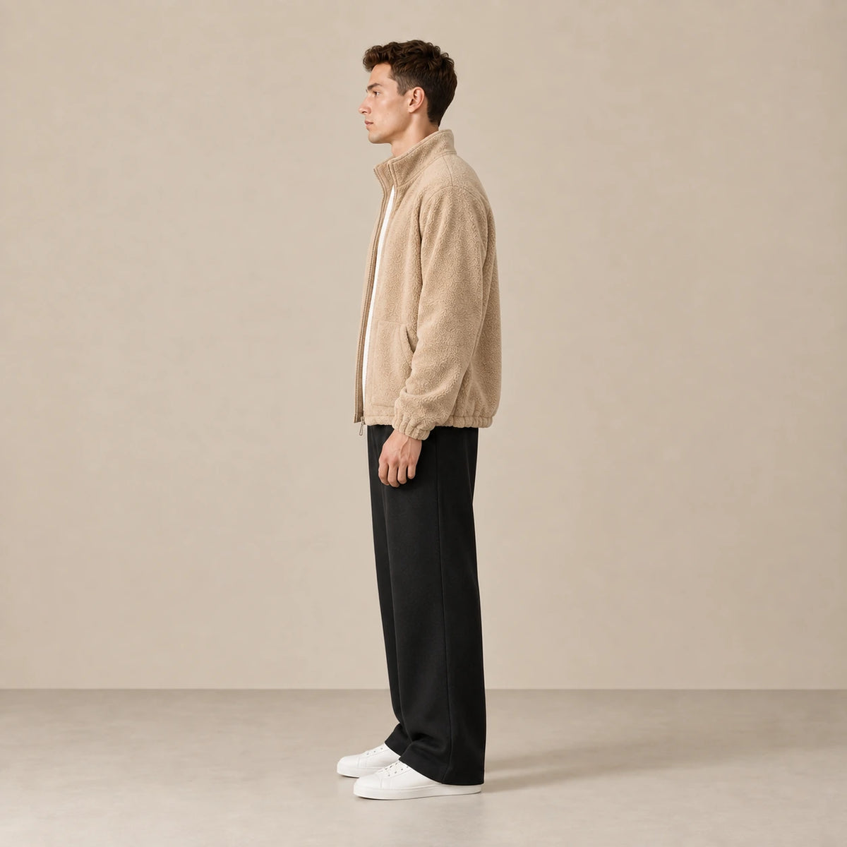 Veste polaire kaki clair à col montant, portée de profil dans le studio IVAREE.