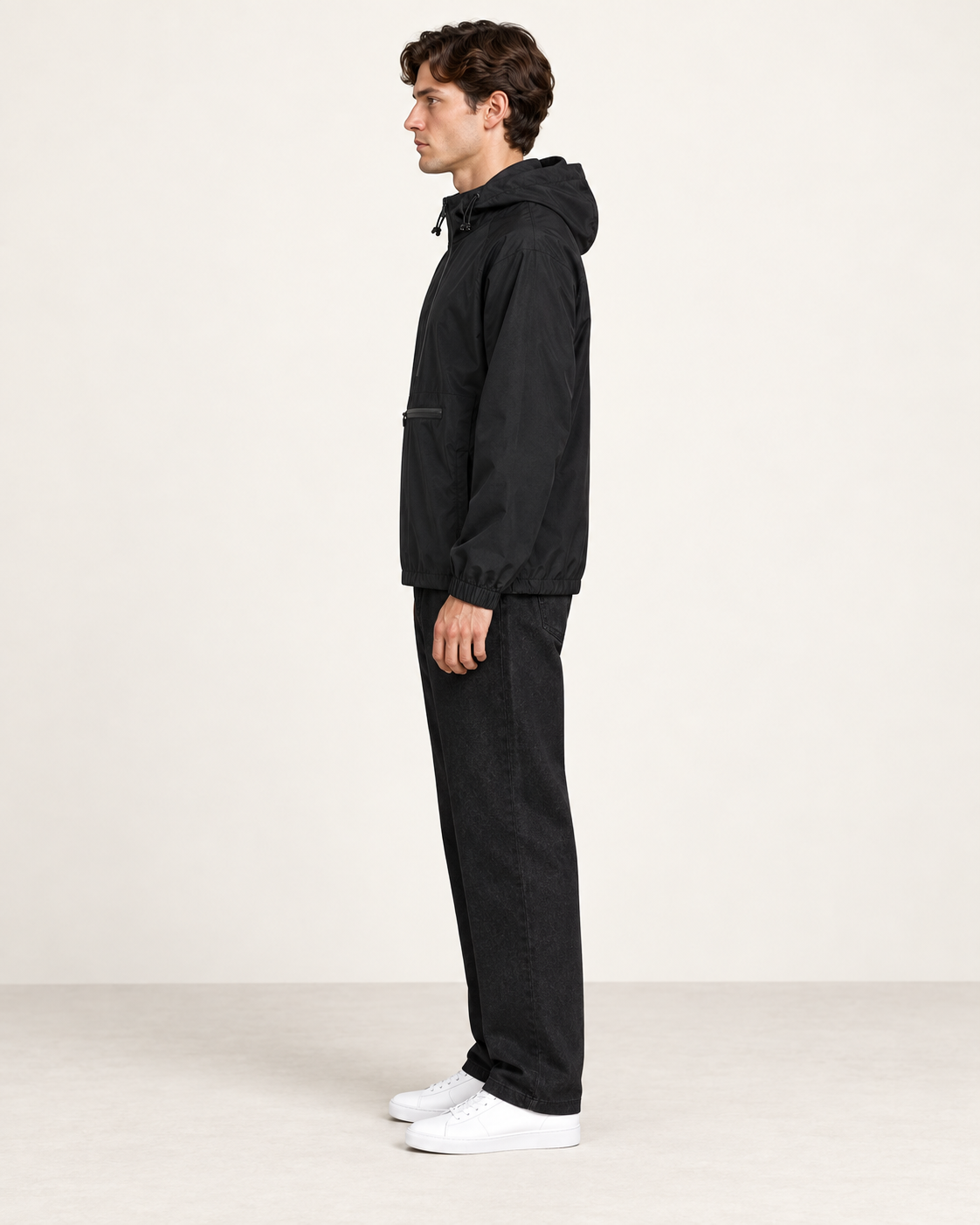 Veste de sport à capuche noir, vue profil, dans le studio IVAREE.